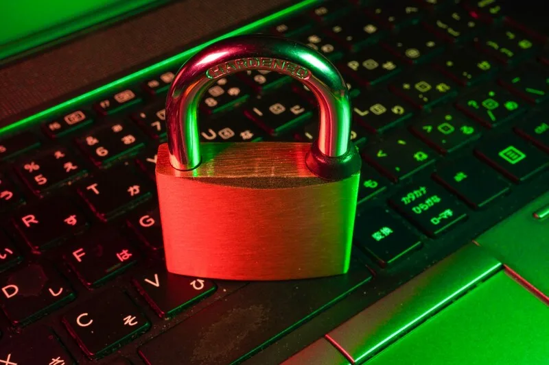 Password manager dashboard on a laptop showing a secure credential vault and team sharing for a small business
